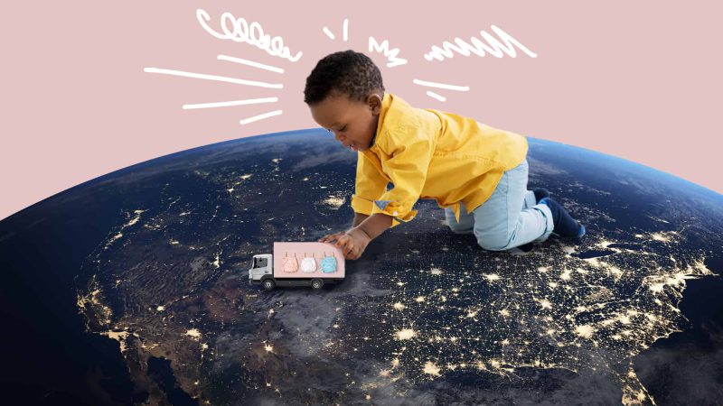 Image of a baby pushing a toy ruck on top of the planet earth