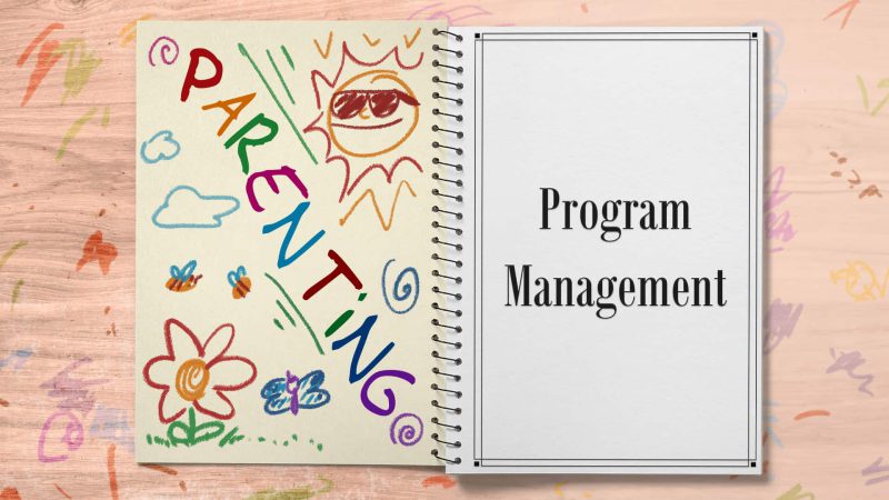 Image of a notebook. The left hand page says "parenting" in crayon with some drawings, the right page says "Project Management" in a regular font