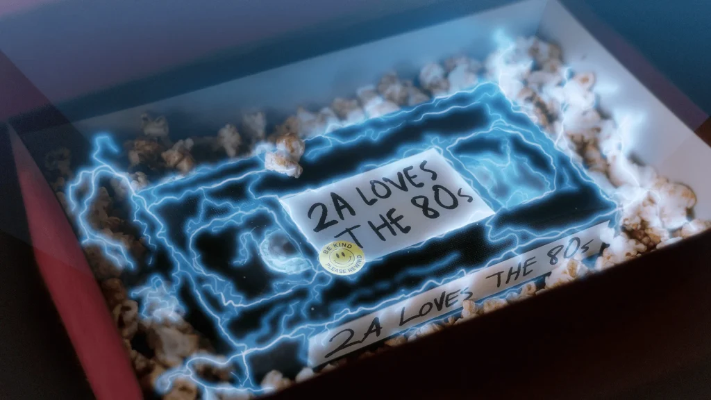 decorative image of a vhs tape in a box with a label that says 2A loves the 80s