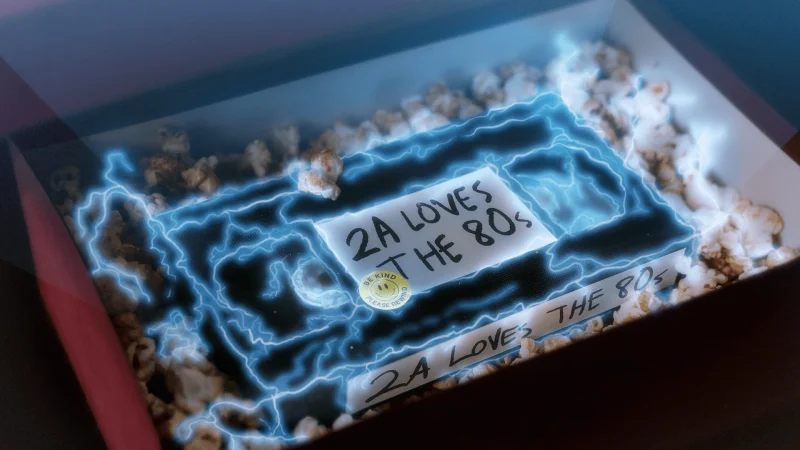 decorative image of a vhs tape in a box with a label that says 2A loves the 80s